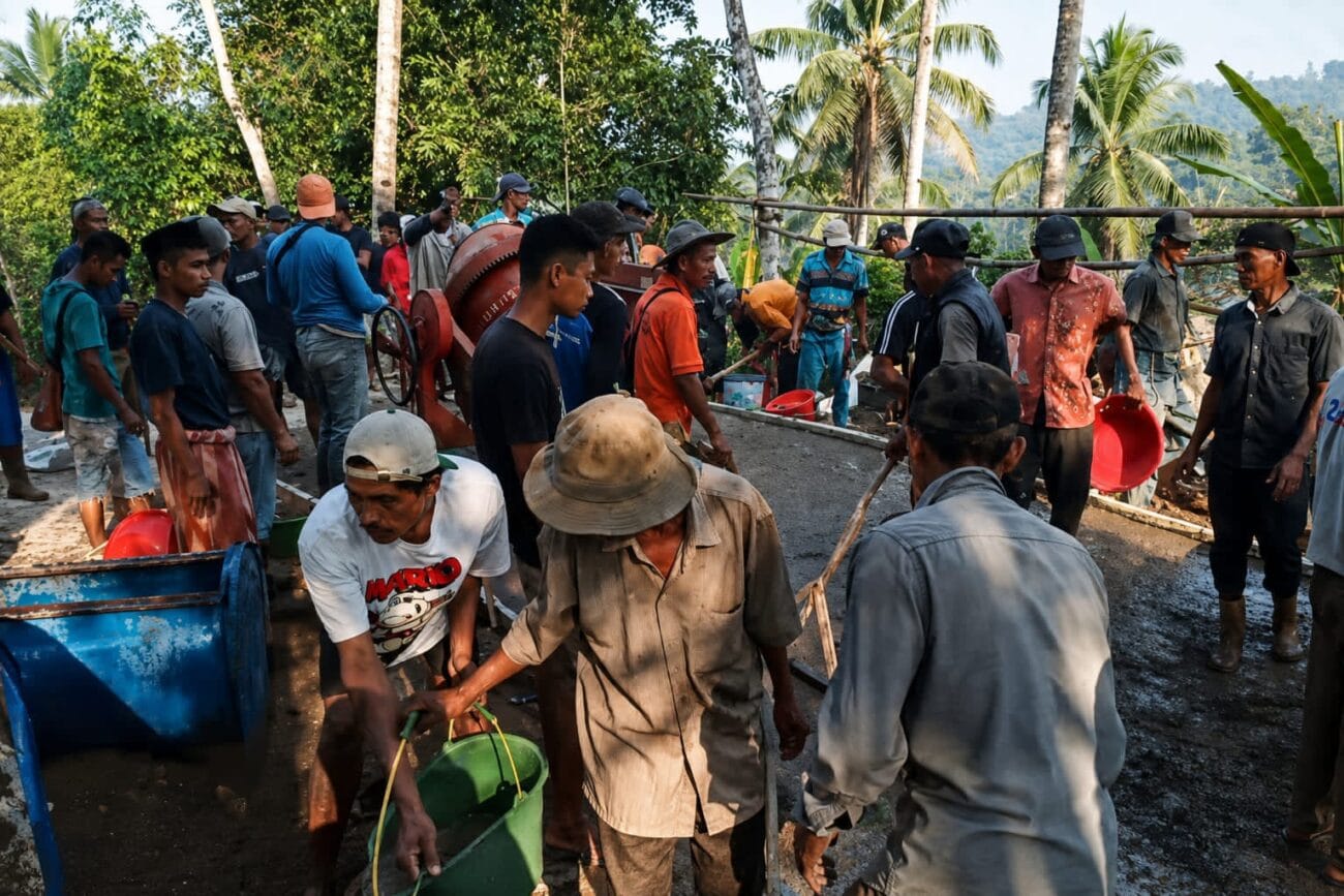 Warga Kampung Palendeng bergotong royong melakukan pengecoran jalan poros desa secara swadaya menggunakan mesin molen di Desa Sindangwangi, Kecamatan Muncang, Kabupaten Lebak.