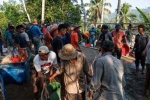 Warga Kampung Palendeng bergotong royong melakukan pengecoran jalan poros desa secara swadaya menggunakan mesin molen di Desa Sindangwangi, Kecamatan Muncang, Kabupaten Lebak.
